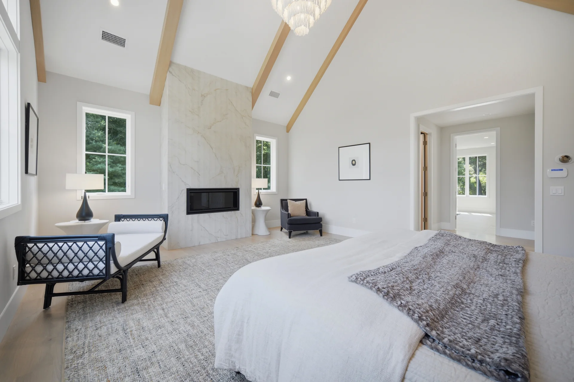 A primary bedroom in a Westport Family Homes build, showing bed placement, furniture, and access to an adjoining bathroom