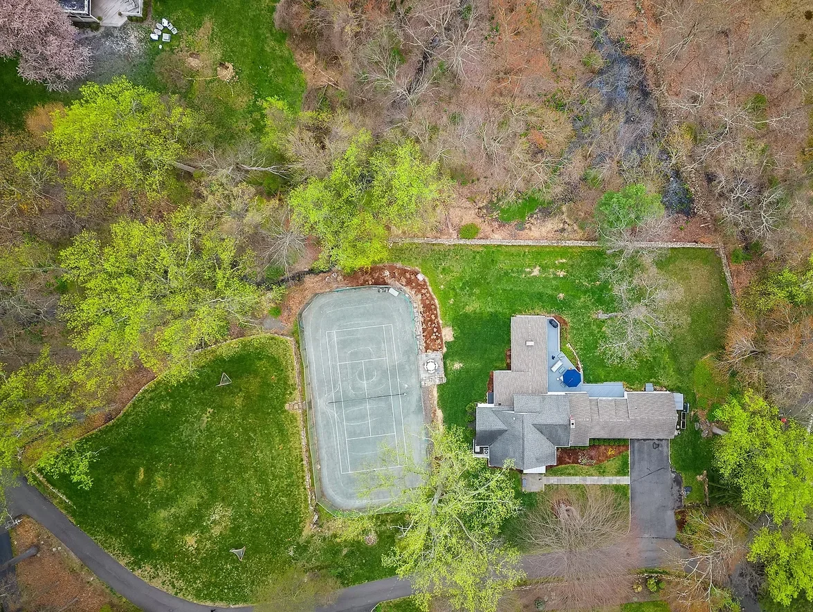 Grounds and private tennis court at a Westport Family Homes property